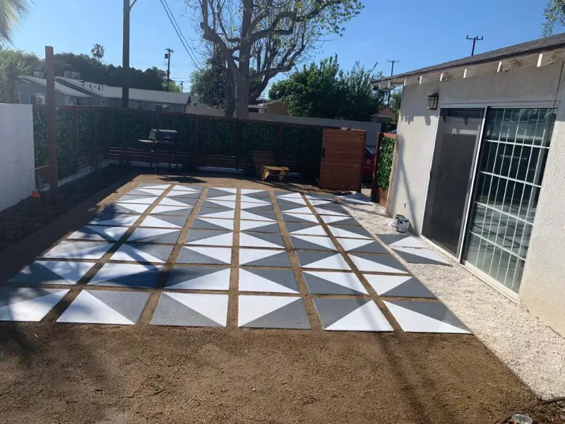 Hardscaping: a checkered tile patio enclosed by a new wood fence